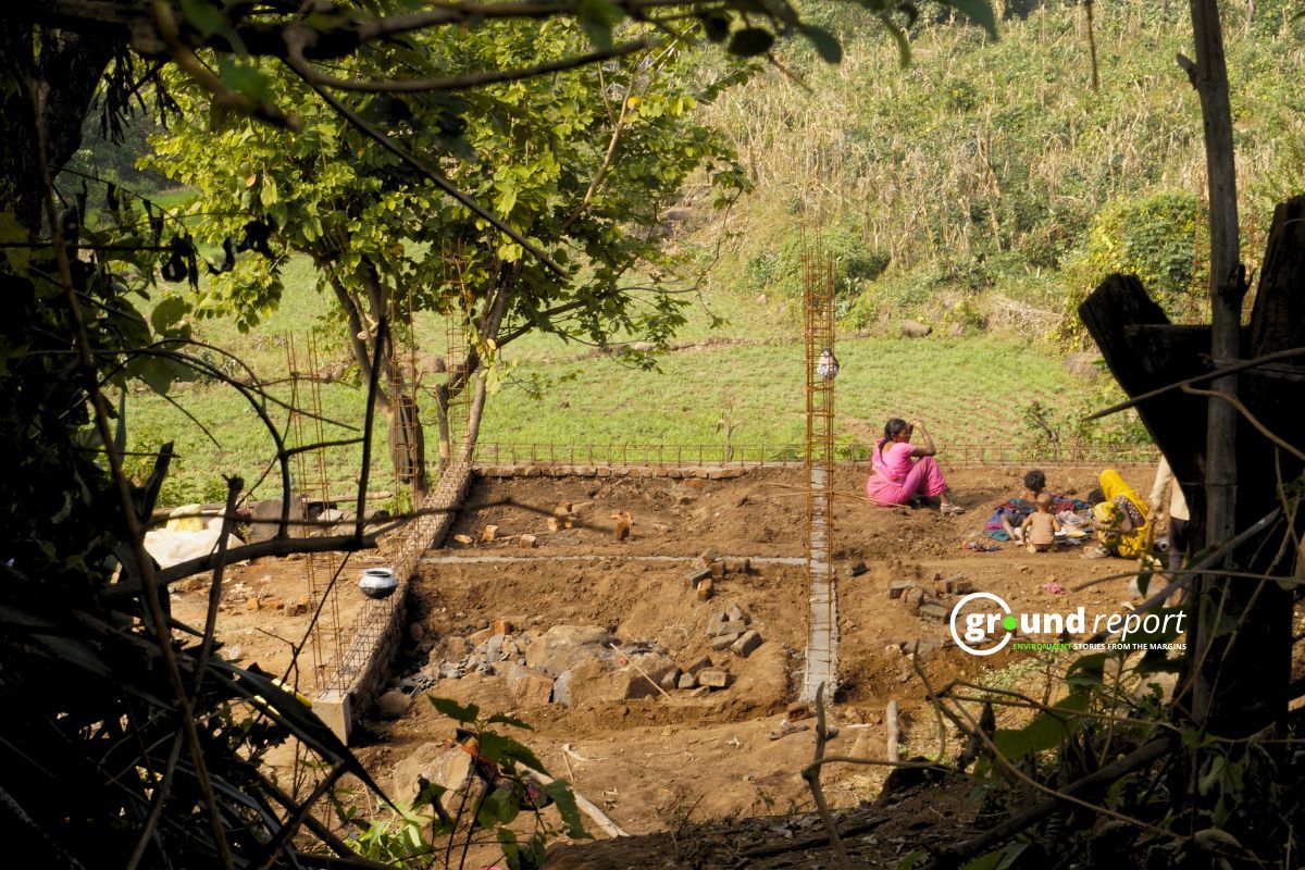 Woman sitting next to the under construction PM Awas in Patalkot