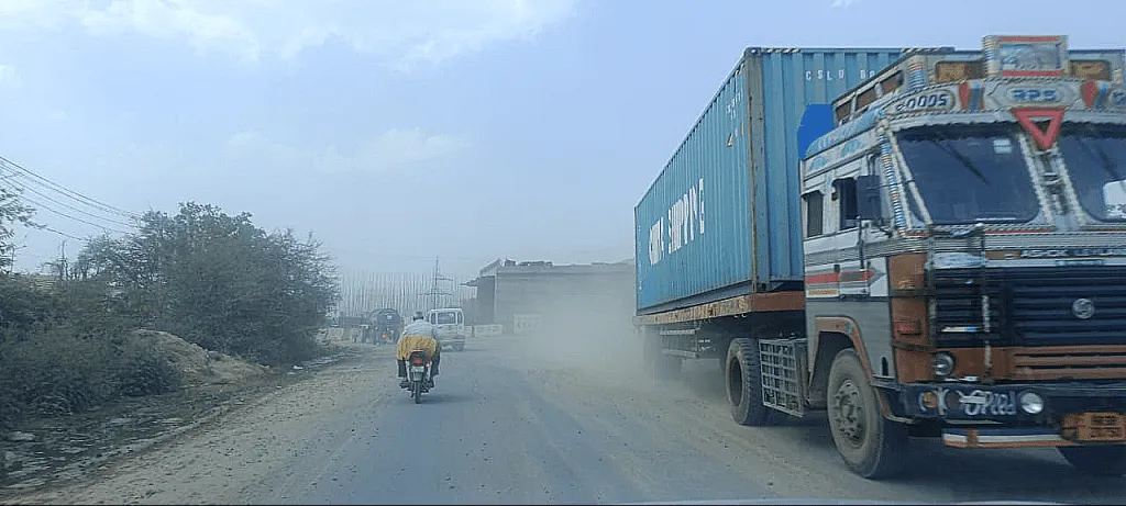 Dust along with vehicle emissions makes it difficult to drive on this road 0